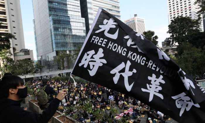 A pro-democracy demonstrator holds a flag as people gather for a lunchtime protest at Chater Garden in Hong Kong, China on Dec. 2, 2019. (Leah Millis/Reuters)