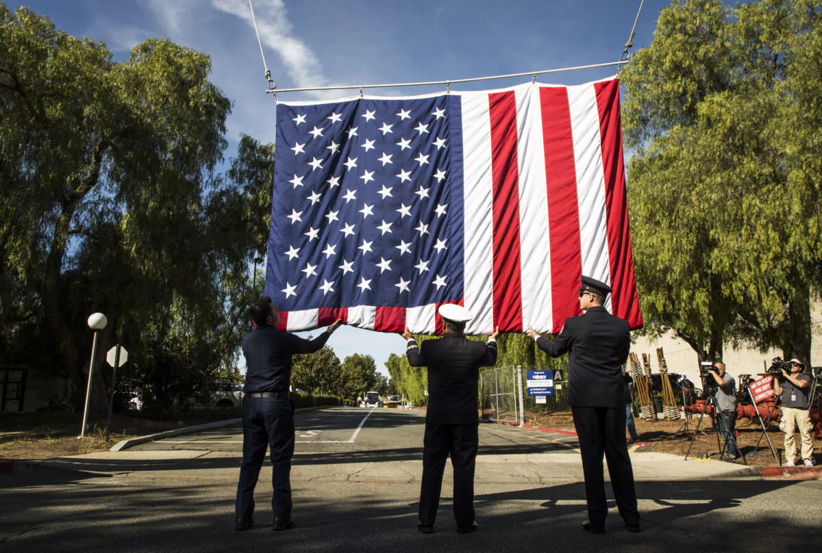 Firefighters help raise an American flag honor of Sgt. Ron Helus at The Calvary Community Church for  memorial service in his honor on November 15, 2018 in Westlake Village, California. Sgt. Helus was killed in a mass shooting at the Borderline Bar and Grill in Thousand Oaks, California on November 7.  Barbara Davidson/Getty Images