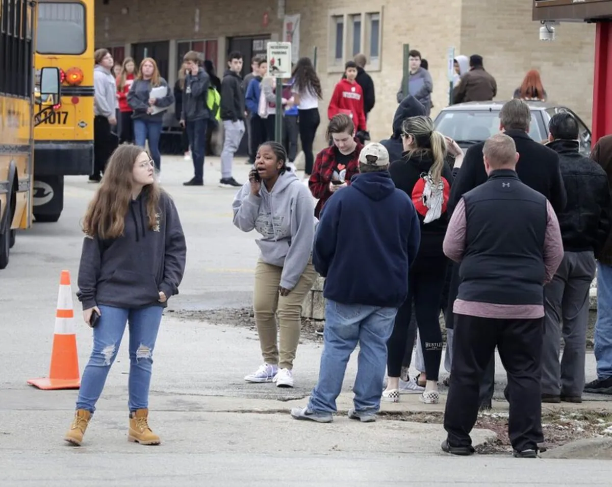 Waukesha South High School students find their waiting parents and friends and hug after they leave the building following shots fired inside the school, Monday, December 2, 2019. A suspect is in custody after a student exchanged gunfire with a school resource officer Monday morning, a spokeswoman for the school district confirmed. (Rick Wood/Milwaukee Journal-Sentinel via AP)
