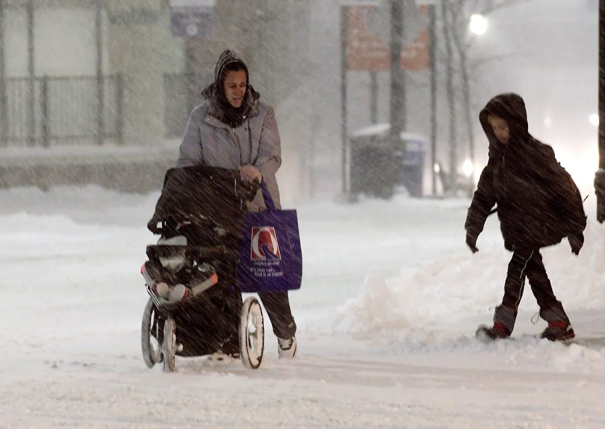 A family walks up Front Street during a snow storm in Worcester, Mass., on Dec. 1, 2019. (Christine Peterson/Worcester Telegram & Gazette via AP)