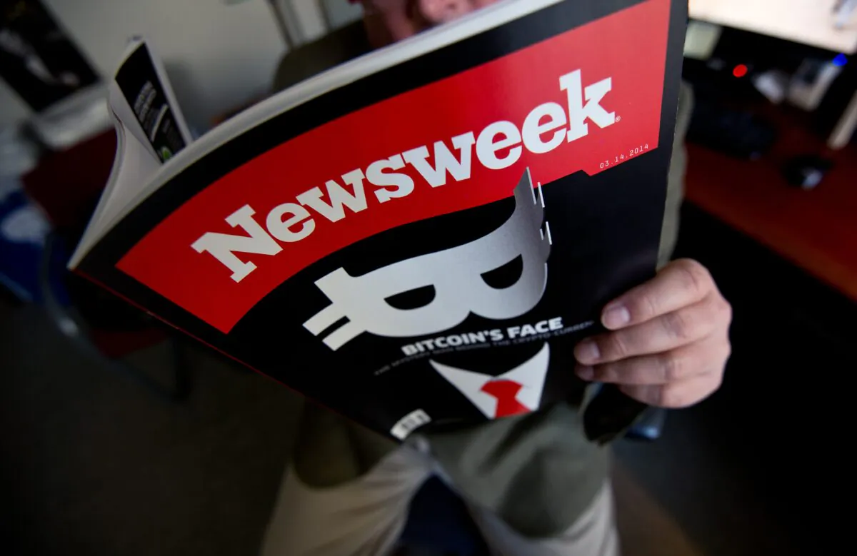 This photo illustration shows a man reading a copy of the new print edition of Newsweek magazine in Washington on March 10, 2014. (Nicholass Kamm/AFP via Getty Images)