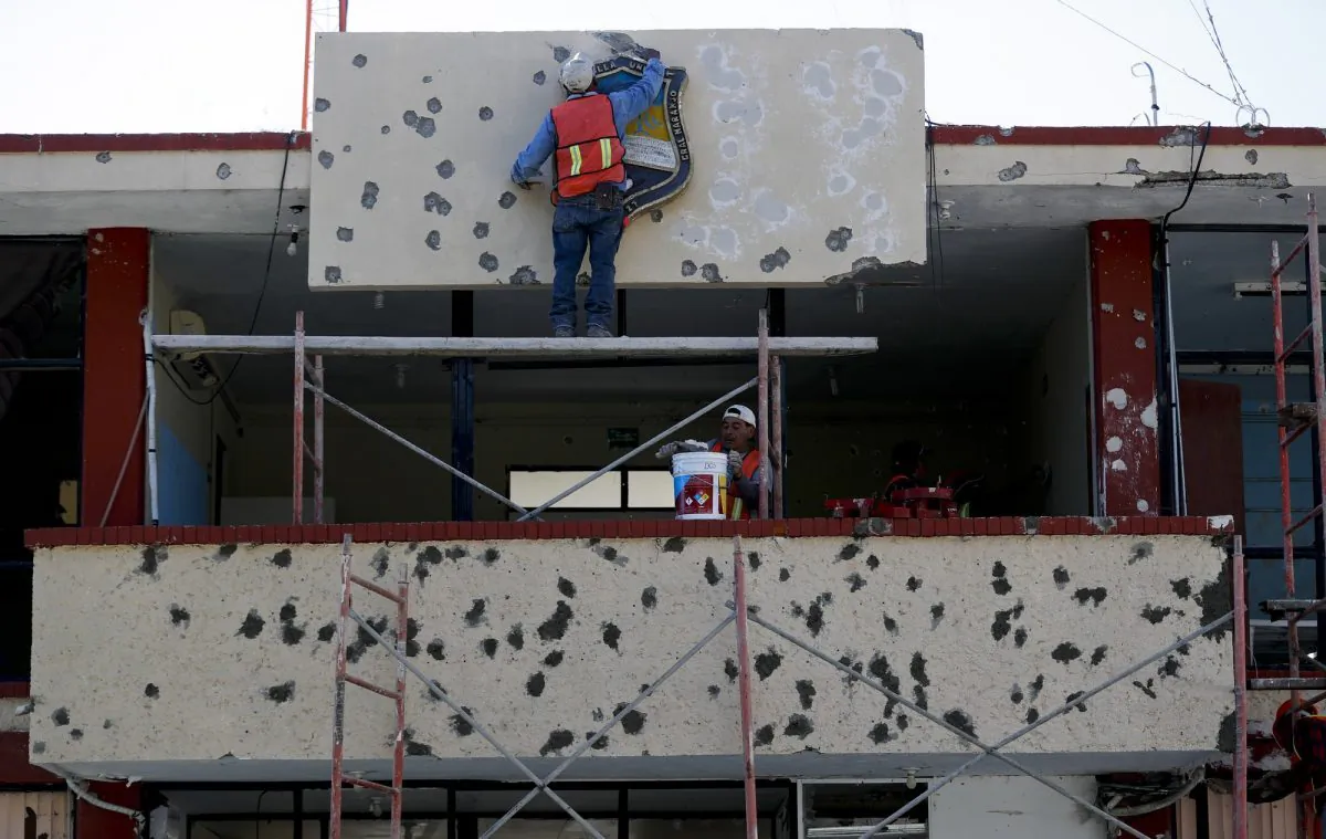 Workers repair the facade of City Hall riddled with bullet holes, in Villa Union, Mexico, on Dec. 2, 2019. (Eduardo Verdugo/AP Photo)