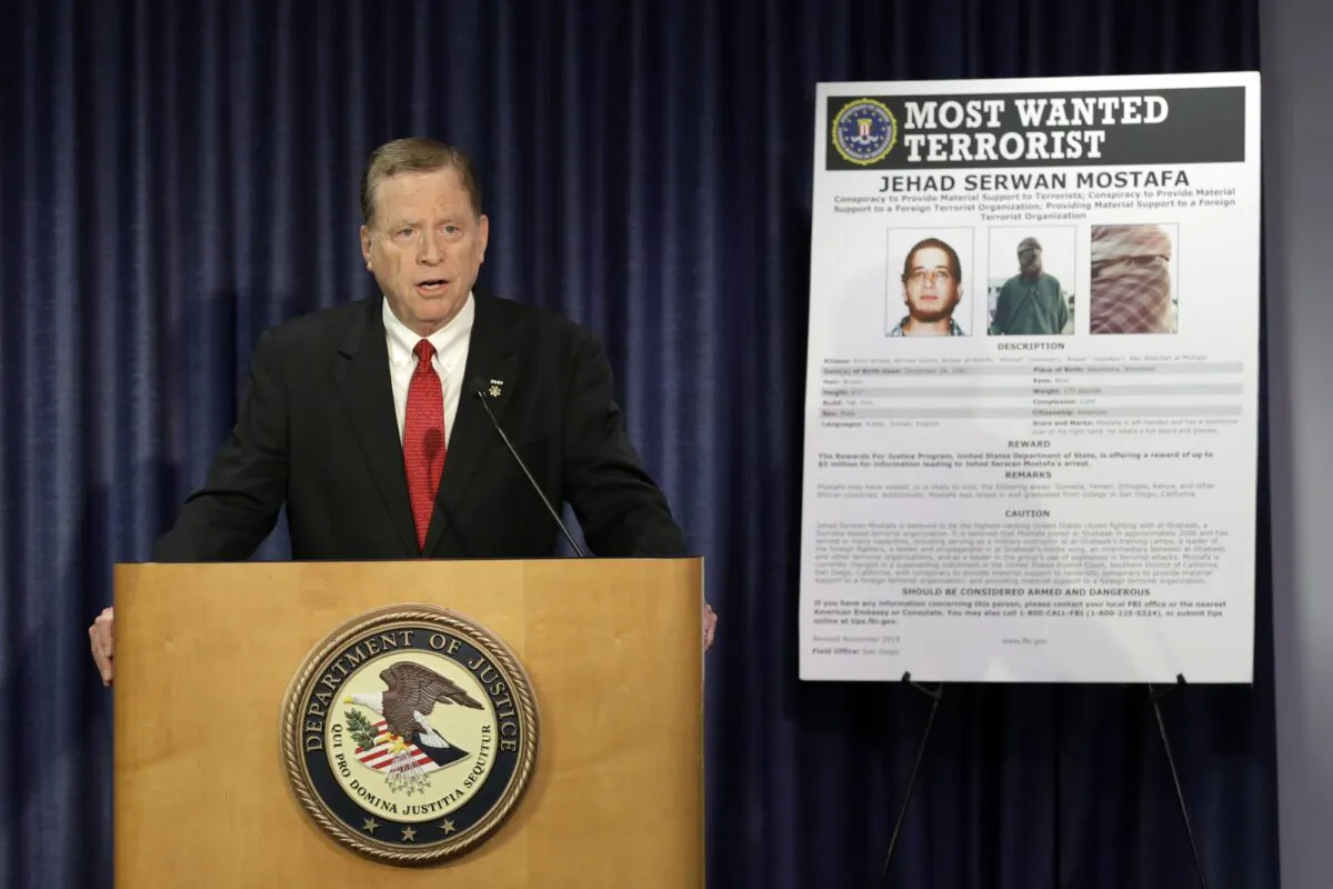 U.S Attorney Robert Brewer speaks in front of an FBI poster depicting Jehad Serwan Mostafa during a news conference in San Diego, California on Dec. 2, 2019. (Gregory Bull/AP Photo)