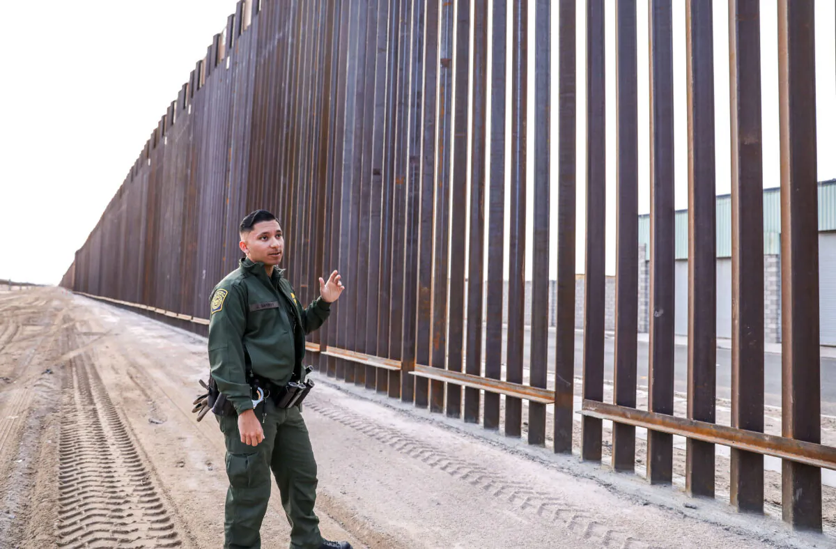 Border Patrol agent Jose Garibay stands next to part of the 30-foot high, 22-mile new fence on the U.S–Mexico border east of San Luis in Yuma, Ariz., on Nov. 27, 2019. (Charlotte Cuthbertson/The Epoch Times)