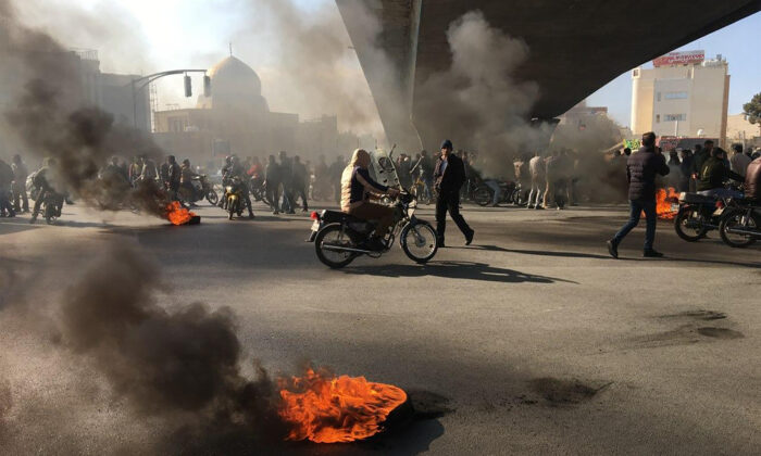 Iranian protesters rally amid burning tires during a demonstration against an increase in gasoline prices, in the central city of Isfahan on November 16, 2019. (Photo by -/AFP via Getty Images)