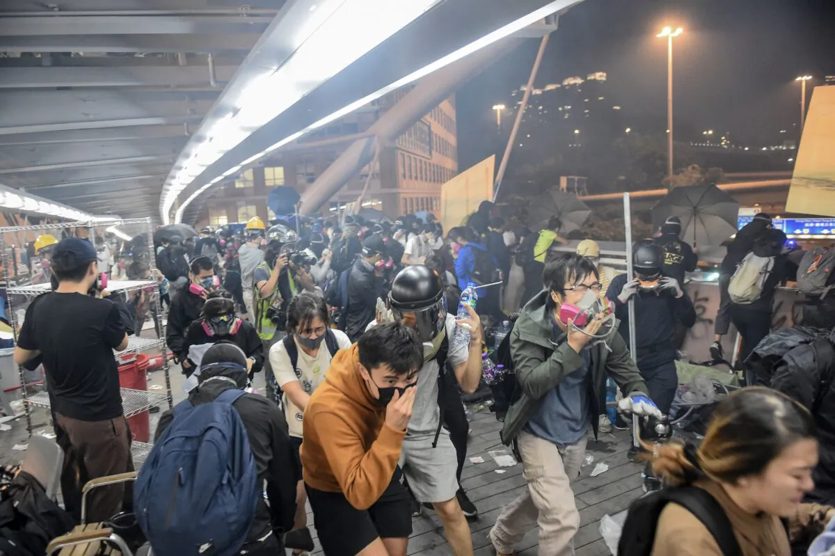 Protesters run away as riot police fire tear gas at Hong Kong Polytechnic University campus and from police, in Hung Hom district in Hong Kong on November 18, 2019.  (Ye Aung Thu/AFP via Getty Images)