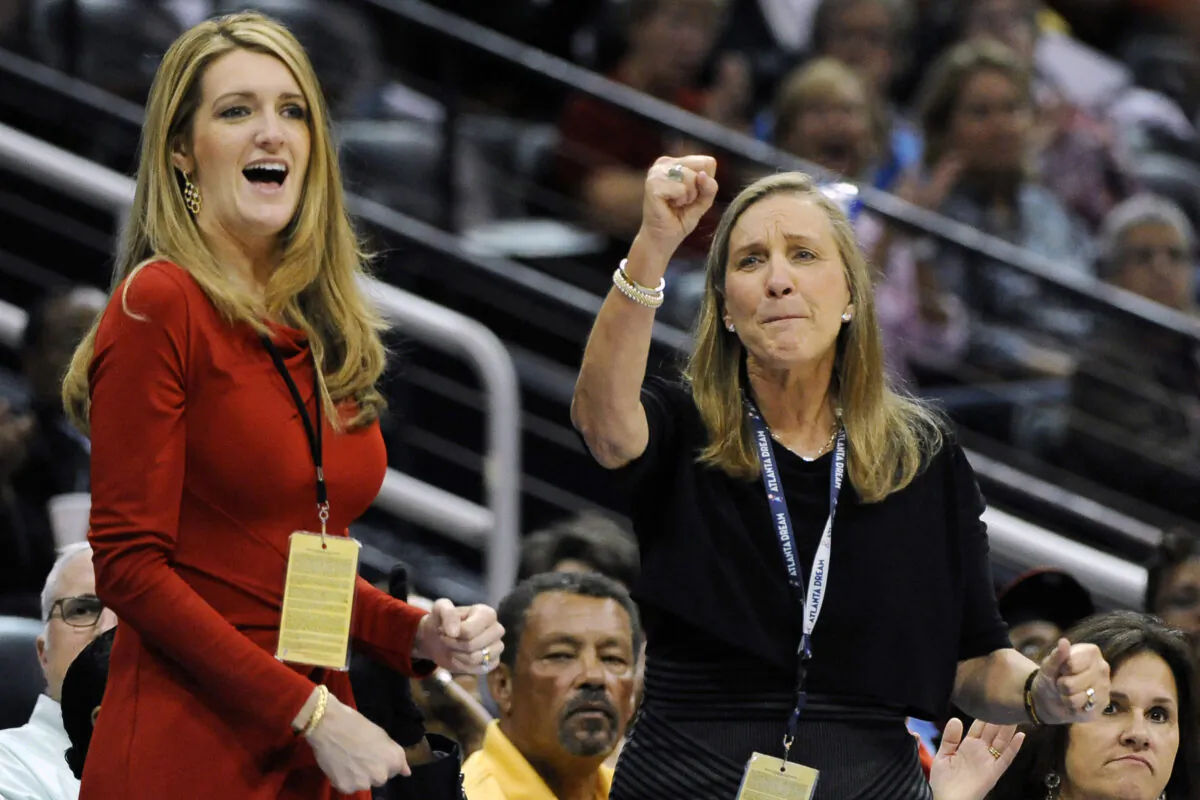 Mary Brock (R) and Kelly Loeffler cheer from their courtside seats as the Atlanta Dream basketball team plays in the second half of their WNBA basketball game, in Atlanta on Sept. 6, 2011. (David Tulis/AP Photo)