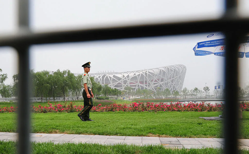 A paramilitary guard patrols the Olympic Green in front of the National Stadium in Beijing on July 2, 2008. (Frederic J. Brown/AFP via Getty Images)