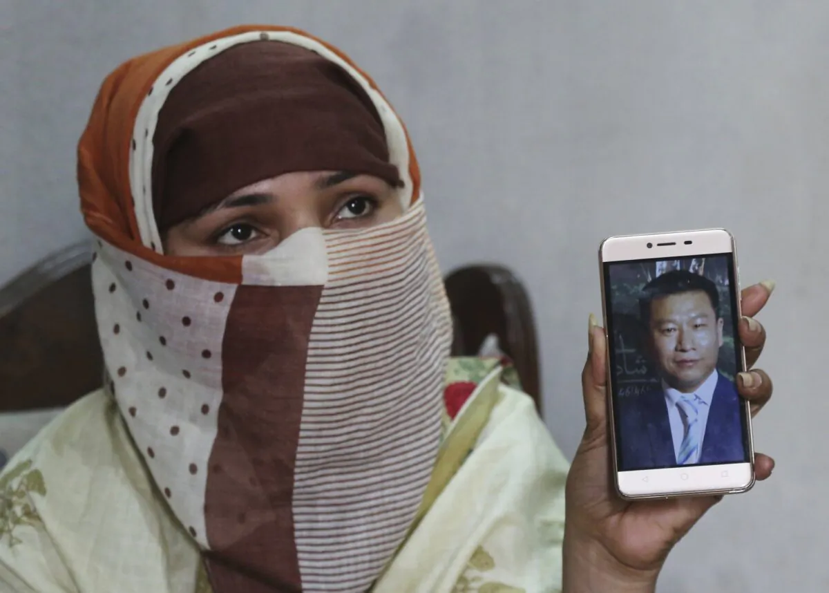Sumaira, a Pakistani woman, shows a picture of her Chinese husband in Gujranwala, Pakistan, on May 22, 2019. Sumaira, who didn't want her full name used, was raped repeatedly by Chinese men at a house in Islamabad where she was brought to stay after her brothers arranged her marriage to the older Chinese man. (K.M. Chaudary/AP Photo)
