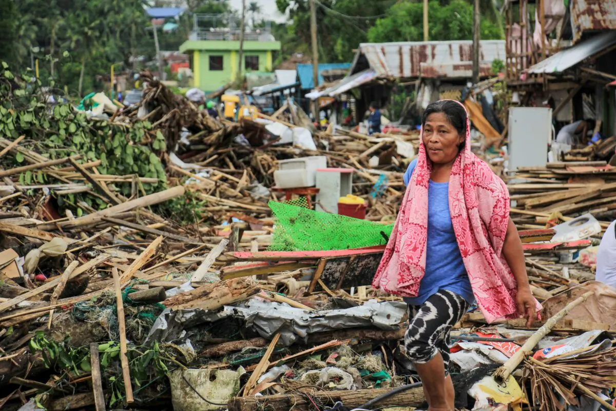 A resident walks past debris from her destroyed houses after Typhoon Kammuri hit the city of Sorsogon, south of of Manila, on Dec. 3, 2019. (RAZVALE SAYAT/AFP via Getty Images)