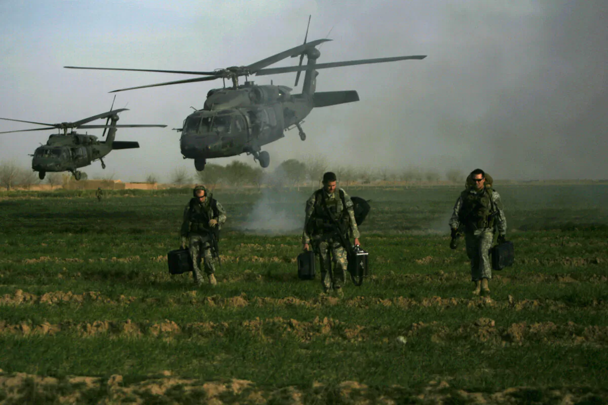 U.S. army special forces walk in a field as Blackhawk helicopters land on Feb. 24, 2010. Patrick Baz/AFP via Getty Images