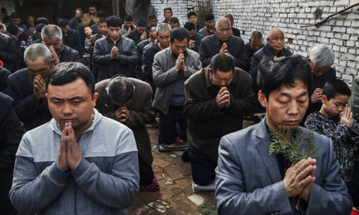Chinese Catholic worshippers kneel and pray during  Palm Sunday Mass during the Easter Holy Week at an 