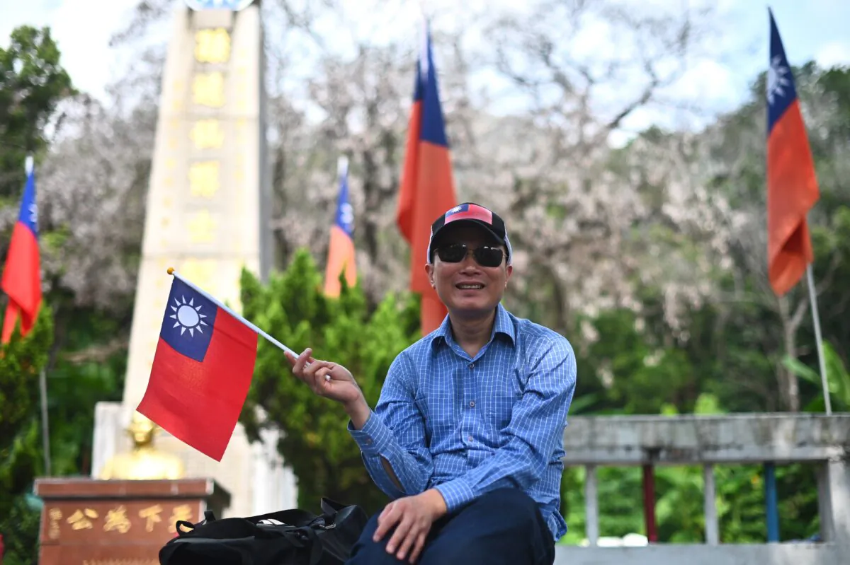 A man holds a republic of China (Taiwan) flag during a flag raising ceremony to mark the 108th anniversary of the founding of the Republic of China, in Tuen Mun District in Hong Kong on October 10, 2019. (PHILIP FONG/AFP via Getty Images)