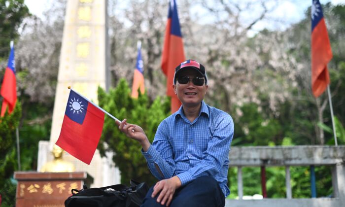 A man holds a republic of China (Taiwan) flag during a flag raising ceremony to mark the 108th anniversary of the founding of the Republic of China, in Tuen Mun District in Hong Kong on October 10, 2019. (PHILIP FONG/AFP via Getty Images)
