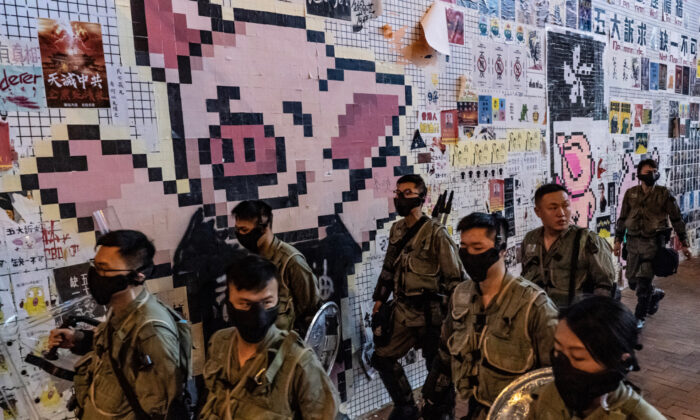 Riot police patrol in front of a so-called Lennon wall with the LIHKG Pig mascot ouside Tai Koo MTR station in Hong Kong, on Oct. 3, 2019. (Anthony Kwan/Getty Images) 