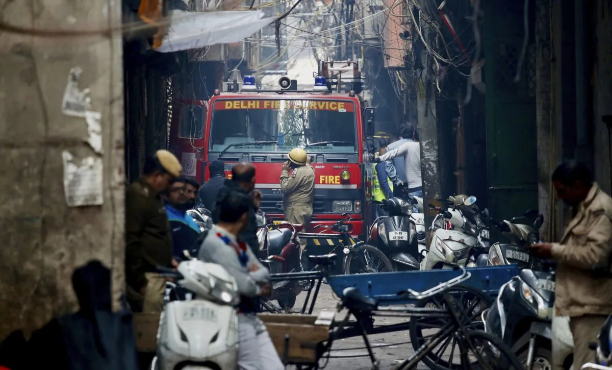 A fire engine stands by the site of a fire in an alleyway, tangled in electrical wire and too narrow for vehicles to access, in New Delhi, India, on Dec. 8, 2019. (Manish Swarup/AP Photo)