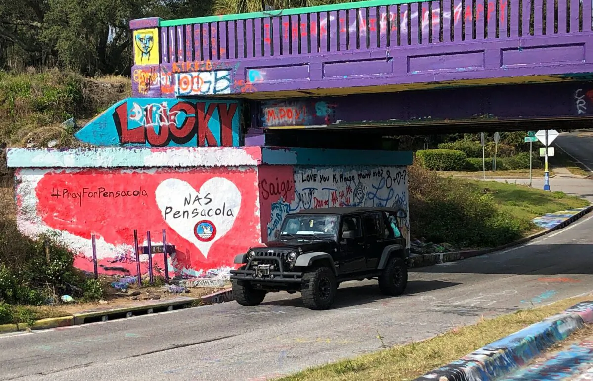 A vehicle drives by a tribute to victims of the Naval Air Station Pensacola that was freshly painted on what’s known as Graffiti Bridge in downtown Pensacola, Fla., on Dec. 7, 2019.  (Brendan Farrington/AP Photo)