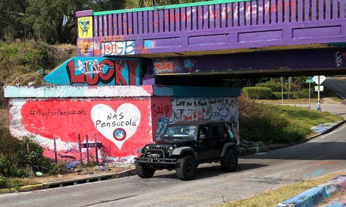 A vehicle drives by a tribute to victims of the Naval Air Station Pensacola that was freshly painted on what’s known as Graffiti Bridge in downtown Pensacola, Fla., on Dec. 7, 2019.  (Brendan Farrington/AP Photo)