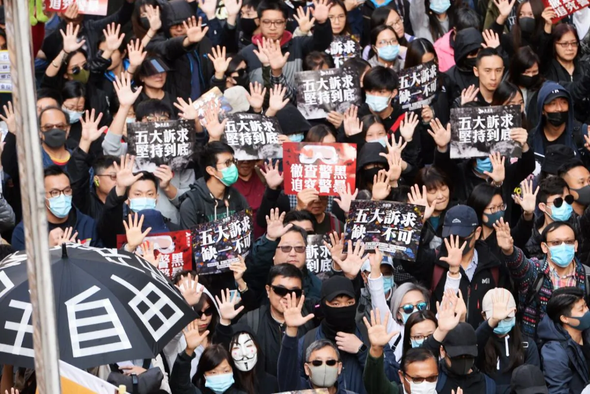 Protesters hold up their hands in a sign of calling for their five demands in a march in Hong Kong on Dec. 8, 2019. (Sung Pi Lung/The Epoch Times)