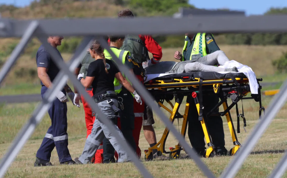 Emergency services attend to an injured person arriving at the Whakatane Airfield after the volcanic eruption on White Island, New Zealand on Monday, Dec. 9, 2019, (Alan Gibson/New Zealand Herald via AP)
