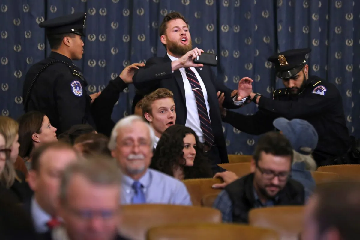 Infowars host Owen Shroyer shouts as he is removed by police after interrupting a House Judiciary Committee hearing on impeachment in the Longworth House Office Building on Capitol Hill in Washington on Dec. 9, 2019. (Chip Somodevilla/Getty Images)
