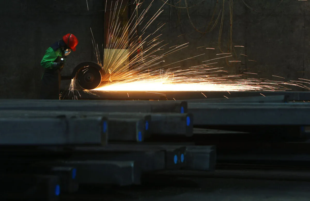 A worker polishes steel products at a stainless steel factory in Qingtian County of Zhejiang Province, China on May 6, 2008. (China Photos/Getty Images)