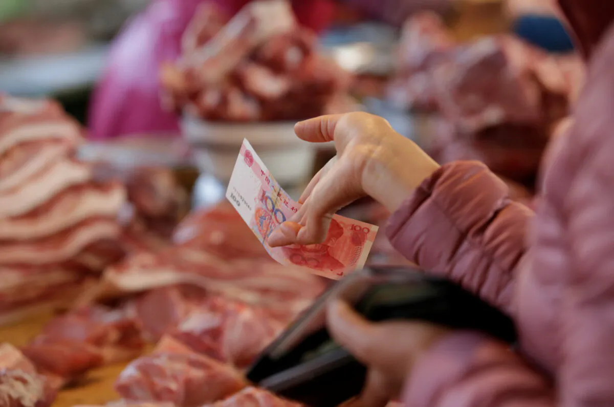 A customer pays a vendor at a market in Beijing, China, on March 25, 2016. (Jason Lee/Reuters)
