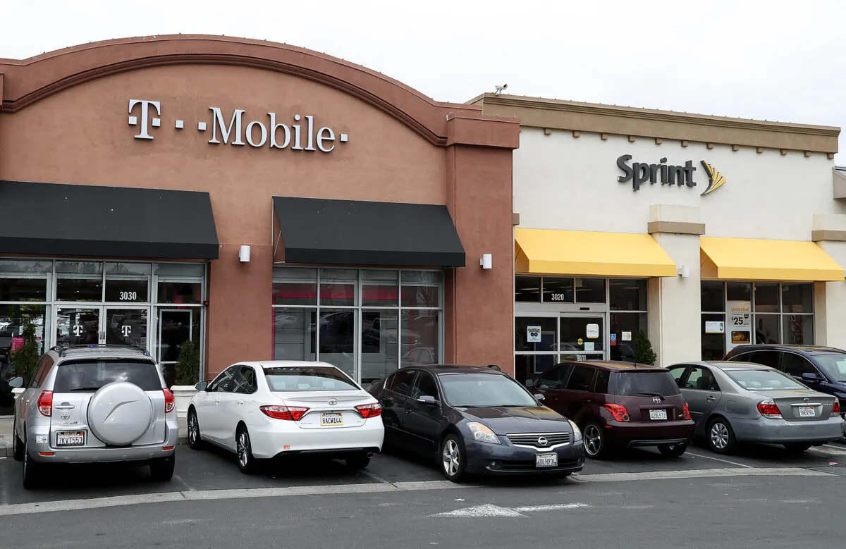 A T-Mobile and Sprint store sit side-by-side in a strip mall on April 30, 2018 in El Cerrito, Calif. (Justin Sullivan/Getty Images)