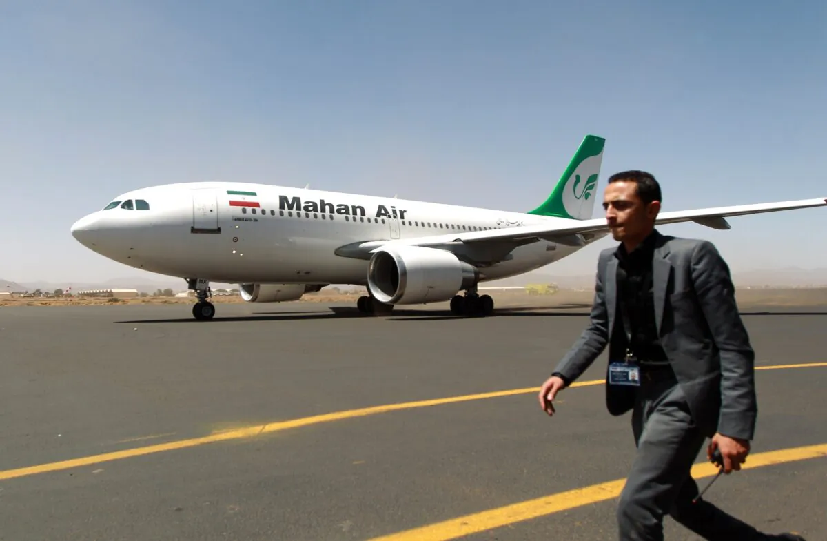 A Yemeni airport personnel walks past an airplane of Mahan Air as it sits at the tarmac after landing at Sanaa International Airport in the Yemeni capital on March 1, 2015 a day after officials from the Shiite militia-controlled city signed an aviation agreement with Tehran. Western-backed President Abedrabbo Mansour Hadi, who fled last weekend an effective house arrest by the Huthis in Sanaa, slammed the agreement as "illegal," according to an aide. AFP PHOTO / MOHAMMED HUWAIS        (Photo credit should read MOHAMMED HUWAIS/AFP via Getty Images)