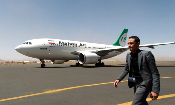 A Yemeni airport personnel walks past an airplane of Mahan Air as it sits at the tarmac after landing at Sanaa International Airport in the Yemeni capital on March 1, 2015 a day after officials from the Shiite militia-controlled city signed an aviation agreement with Tehran. Western-backed President Abedrabbo Mansour Hadi, who fled last weekend an effective house arrest by the Huthis in Sanaa, slammed the agreement as "illegal," according to an aide. AFP PHOTO / MOHAMMED HUWAIS        (Photo credit should read MOHAMMED HUWAIS/AFP via Getty Images)