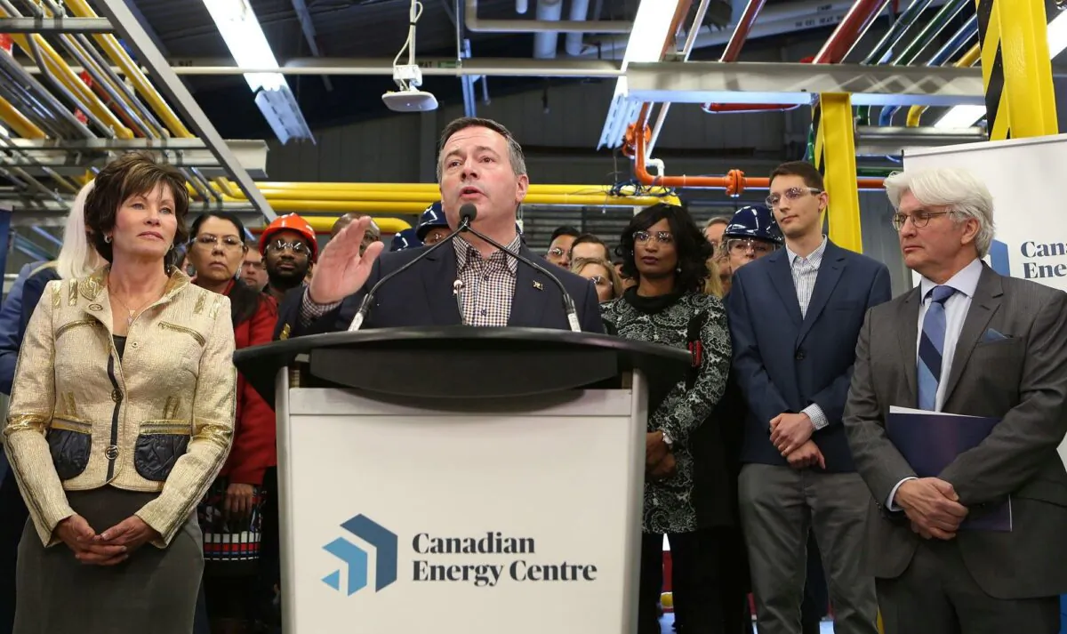 Alberta Premier Jason Kenney announces the launch of the Canadian Energy Centre at SAIT in Calgary on Dec. 11, 2019. Looking on are Energy Minister Sonya Savage (L) and Tom Olsen, managing director of the Energy Centre. (The Canadian Press/Greg Fulmes)