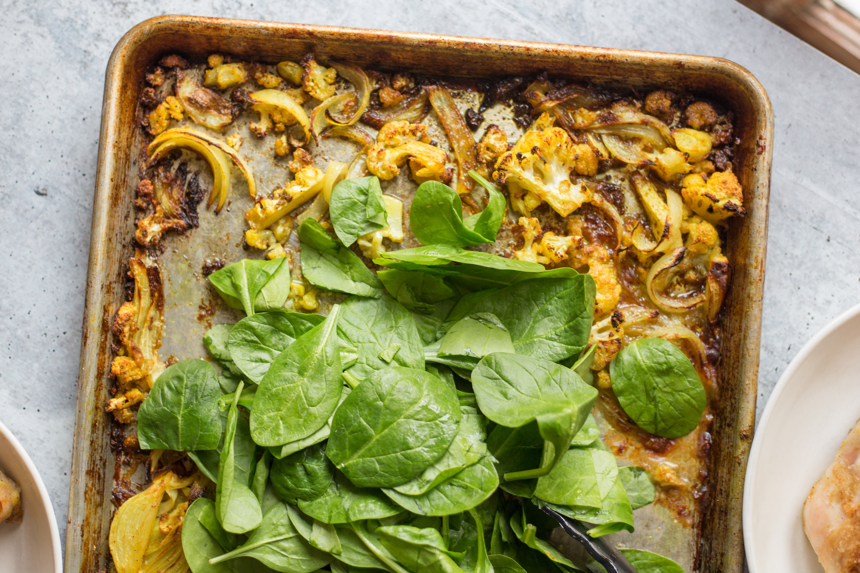 spinach on sheet pan with roasted cauliflower