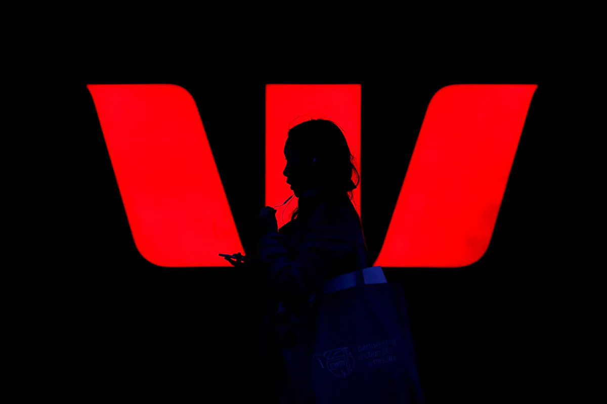 A woman walks past an illuminated logo for Australia's Westpac Bank in Sydney, Australia, on Sept. 6, 2017.   (Reuters/Steven Saphore/File Photo)