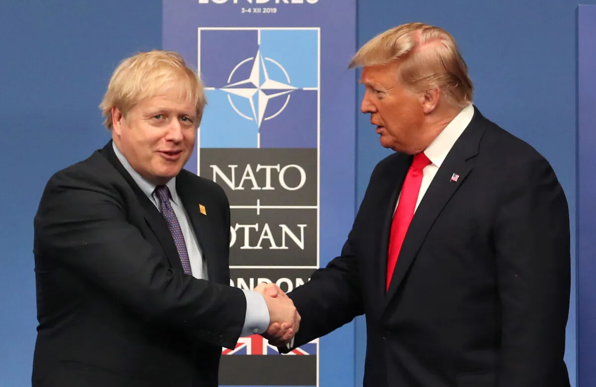 British Prime Minister Boris Johnson shakes hands with U.S. President Donald Trump onstage during the annual NATO heads of government summit on Dec. 4, 2019 in Watford, England. (Steve Parsons-WPA Pool/Getty Images)