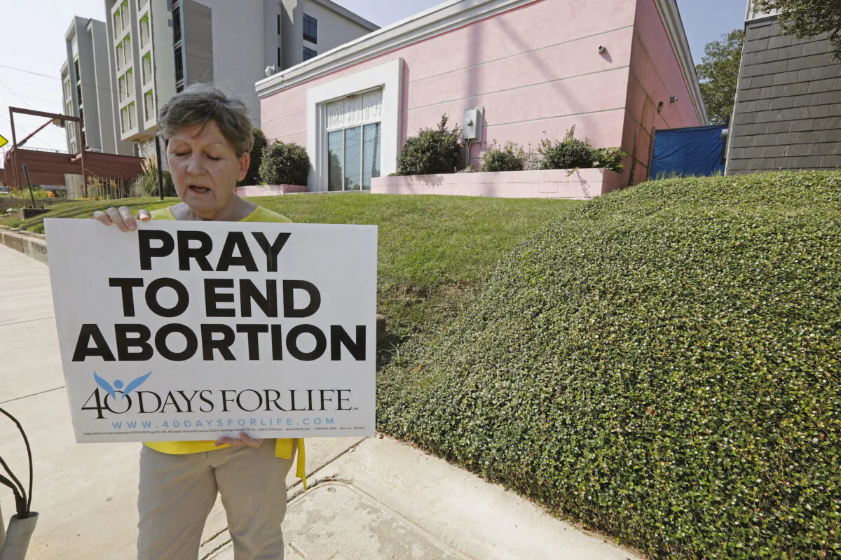 An abortion opponent sings to herself outside the Jackson Womens Health Organization clinic in Jackson, Miss., on Oct. 2, 2019. (Rogelio V. Solis/AP)
