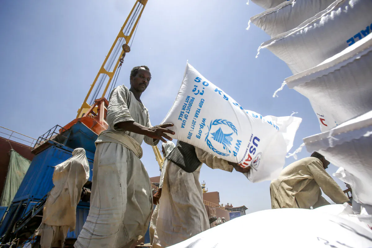 Sudanese dockers unload bags of sorgham (cereal) from one of two US ships carrying humanitarian aid supplies provided by the US development agency USAID, at Port Sudan on the red sea coast on June 5, 2018. (Ashraf Shazly/AFP via Getty Images)