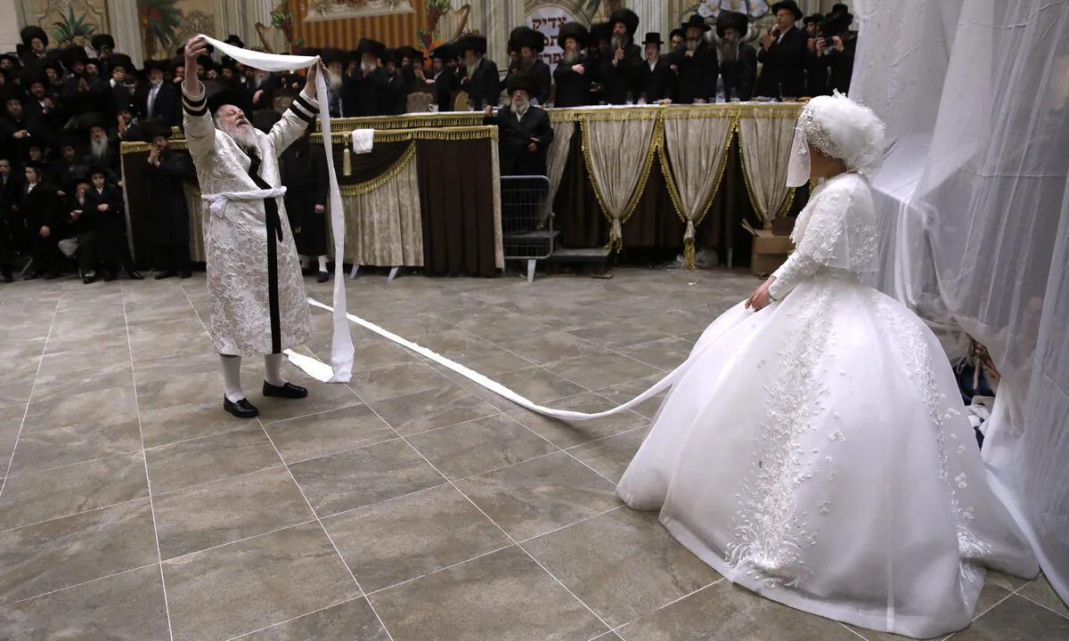 Rabbi Meir Rosenboim (L) of the Premishlan Hasidic dynasty dance in front of his daughter Hana Ritza during the Mitzvah Tantz, a Hasidic custom is which the men dance before the bride on the wedding night, on Dec. 9, 2019 after a wedding feast in the Israeli religious city of Bnei Brak near Tel Aviv. (Menahem Kahana/AFP via Getty Images)