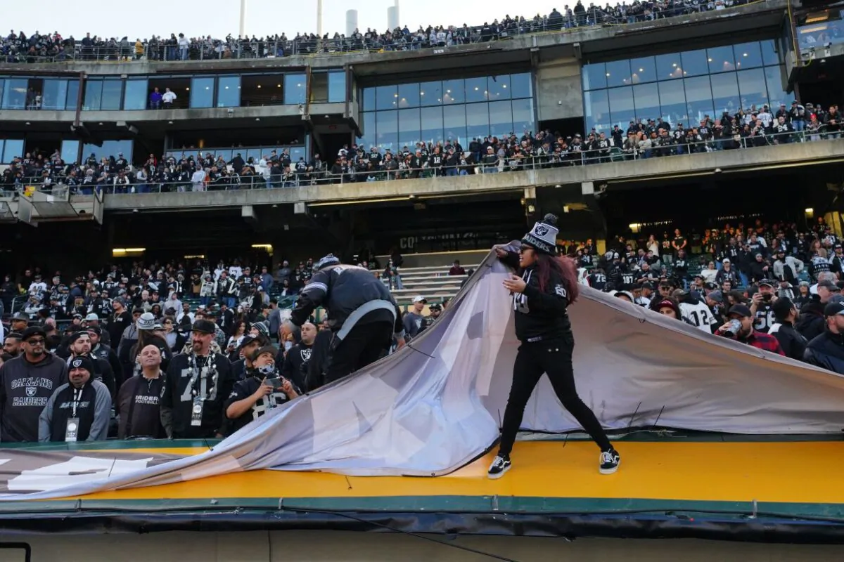 Fans rip banners from the stadium walls after the Oakland Raiders loss to the Jacksonville Jaguars at RingCentral Coliseum in Oakland, California on Dec. 15, 2019. (Daniel Shirey/Getty Images)