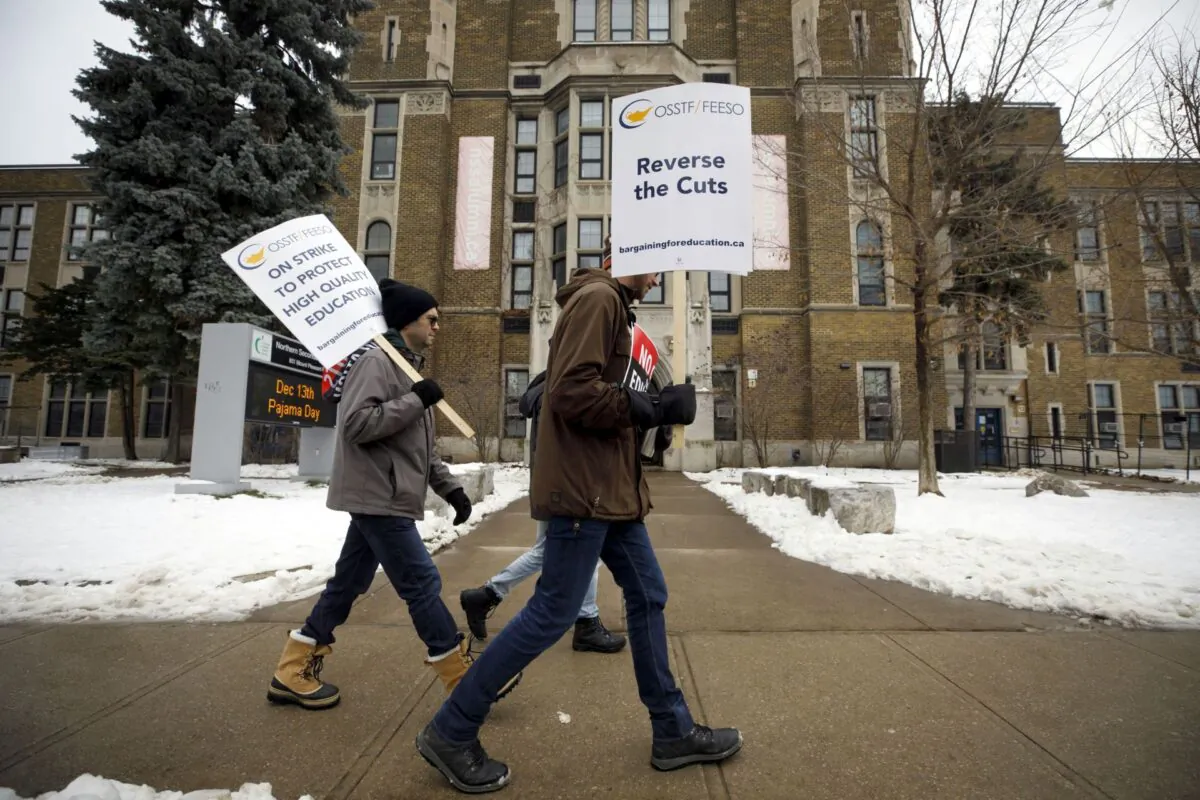 Striking teachers of the Ontario Secondary School Teachers’ Federation walk the picket line outside Northern Secondary School in Toronto on Dec. 4, 2019. (The Canadian Press/Cole Burston)