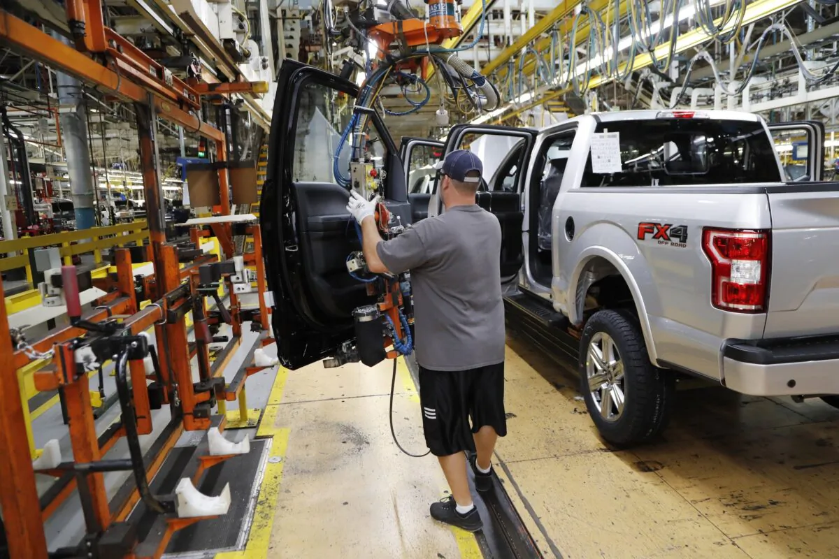United Auto Workers assemblyman installs the front doors on a 2018 Ford F-150 truck being assembled at the Ford Rouge assembly plant in Dearborn, Mich. on Sept. 27, 2018. (Carlos Osorio/AP-File)