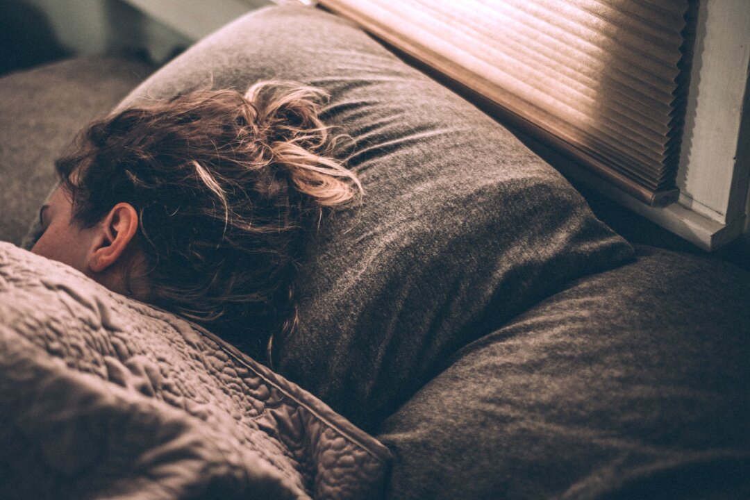 Woman sleeping on bed. (Gregory Pappas/Unsplash)