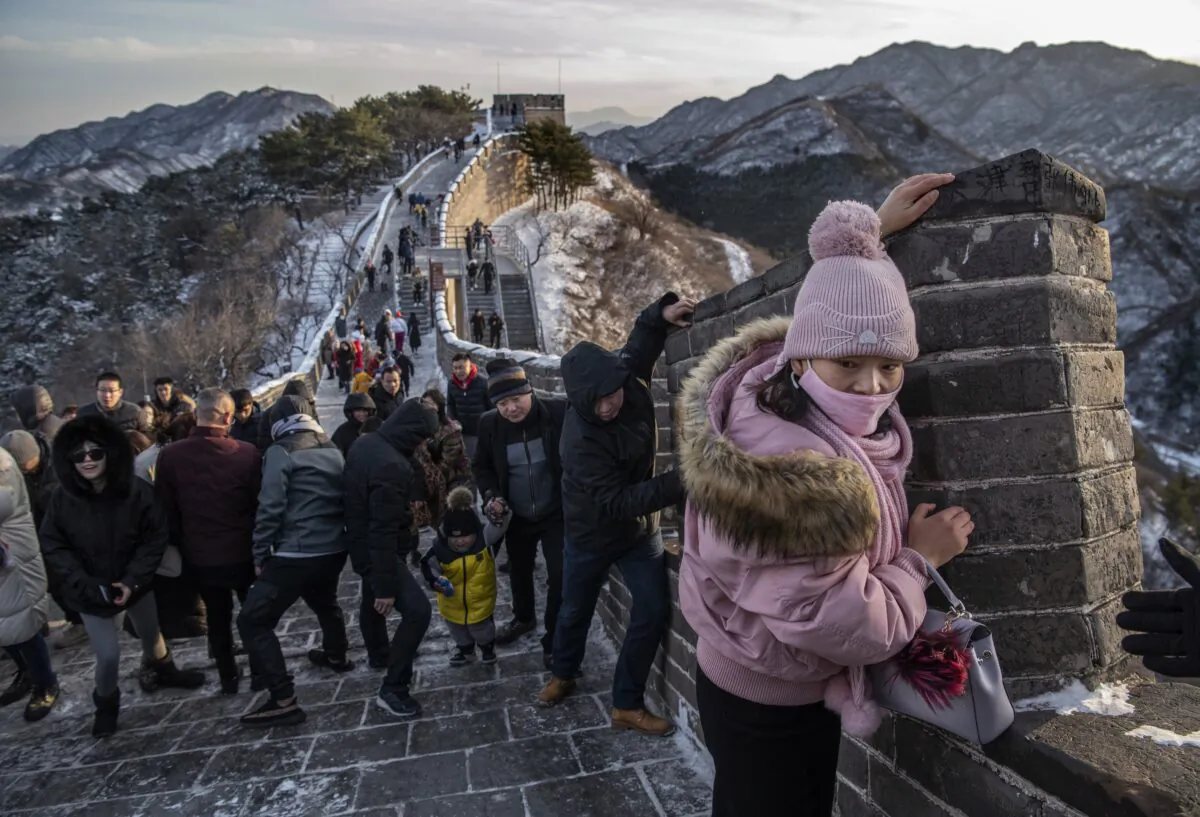 Tourists struggle to climb in the wind on an icy section of the Great Wall at Badaling in Beijing, China, on Nov. 30, 2019. (Kevin Frayer/Getty Images)