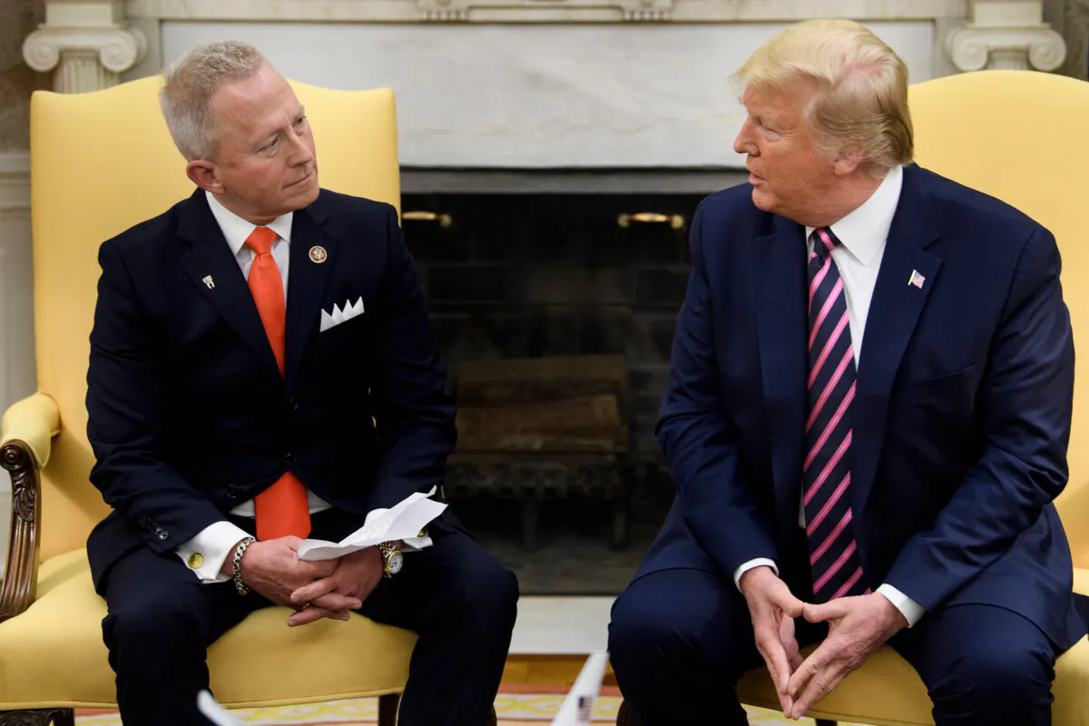 Rep. Jeff Van Drew (NJ), who is switching from the Democratic Party to the Republican Party, listens to US President Donald Trump during a meeting in the Oval Office of the White House on Dec. 19, 2019, in Washington, DC. (Photo by Brendan Smialowski/AFP/Getty Images)