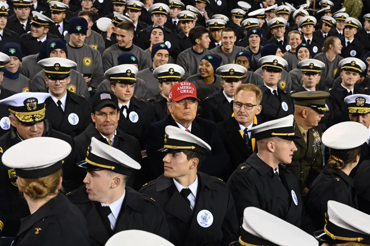 President Donald Trump, center, with U.S. Defense Secretary Mark Esper, center-left, and Acting United States Secretary Thomas Modly, center right, joins Naval Academy cadets during the the Army versus Navy American Football game in Philadelphia, Pa., on Dec. 14, 2019. (Andrew Caballero-Reynolds/AFP via Getty Images)