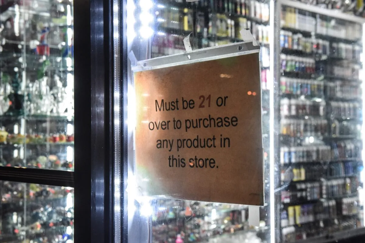 A sign that states "must be over 21" hangs in the store window of a vape shop in New York City on Dec. 19, 2019. (Stephanie Keith/Getty Images)