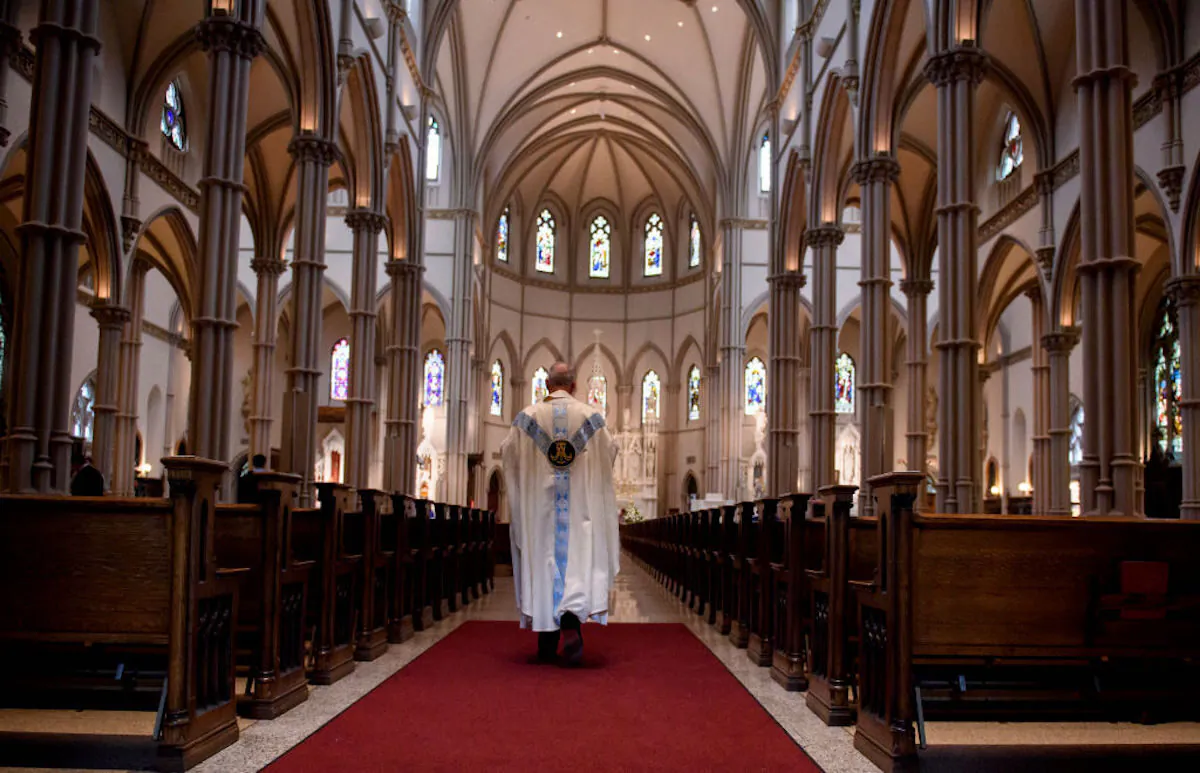 A priest walks to the sanctuary following a mass in Pittsburgh, Pa., on Aug. 15, 2018. (Jeff Swensen/Getty Images)