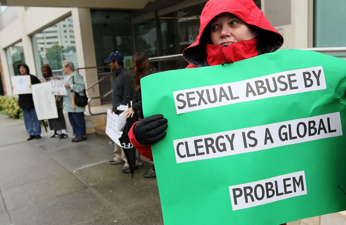 A protester holds a sign in a demonstration with members of the group SNAP, the Survivors Network of those Abused by Priests, outside of the offices of the San Francisco Archdiocese in San Francisco, Calif., on March 29, 2010. (Justin Sullivan/Getty Images)
