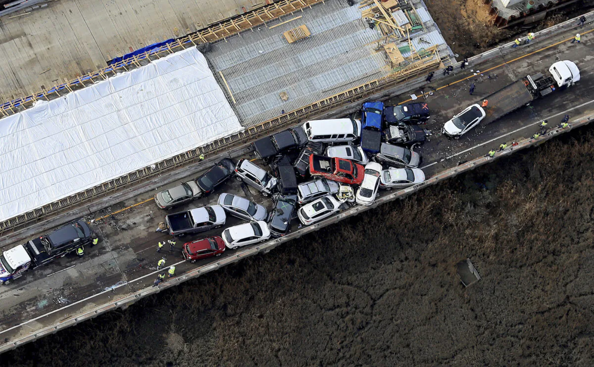 Crews work to clear vehicles from the Queens Creek Overpass on I-64 in York County, Va., on Dec. 22, 2019, after a morning chain-reaction crash that involved multiple vehicles. (Rob Ostermaier/The Daily Press via AP)