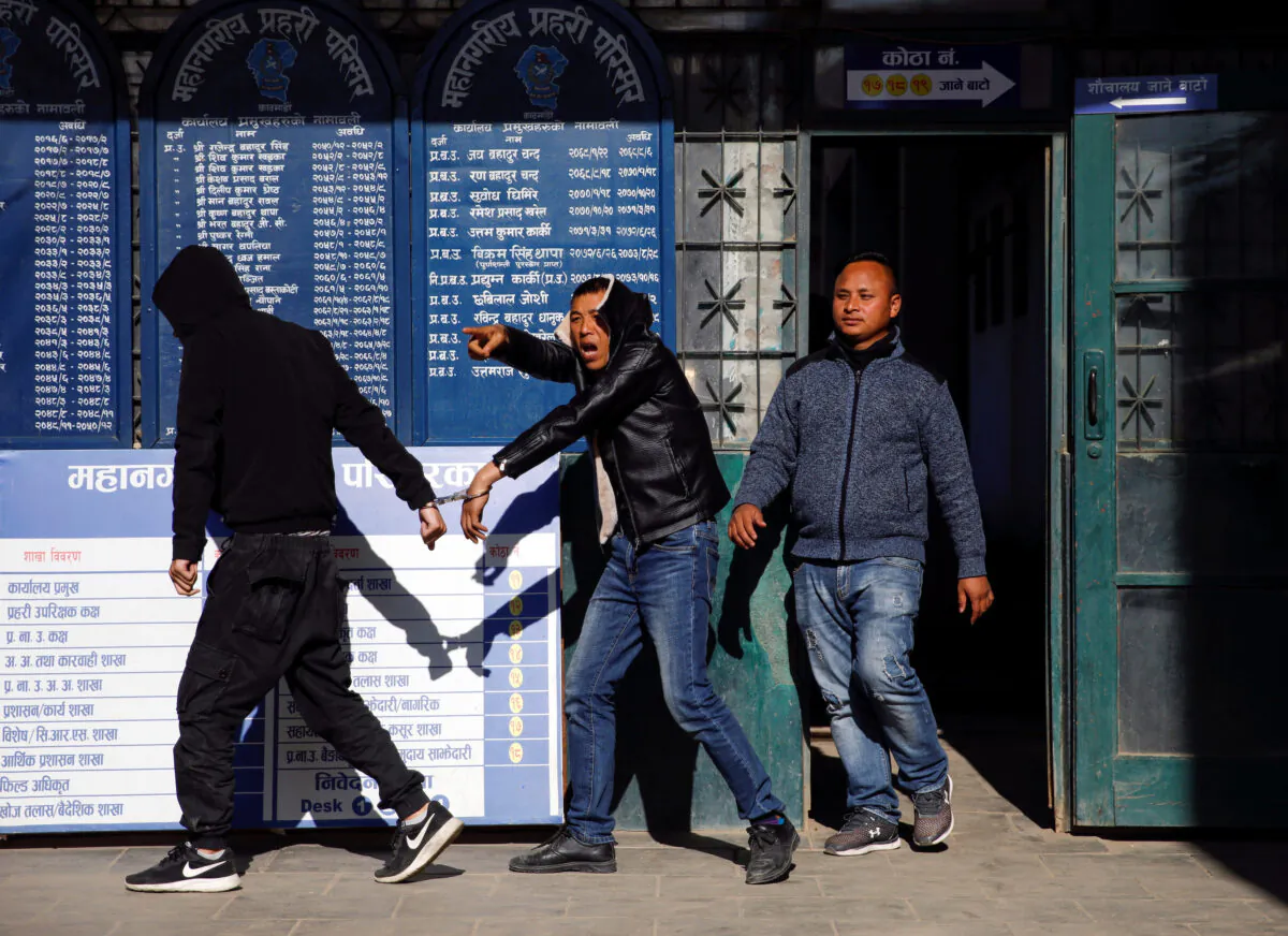 A detained Chinese man reacts towards the media as he walks into the police station in Kathmandu, Nepal on Dec. 24, 2019. (Navesh Chitrakar/Reuters)