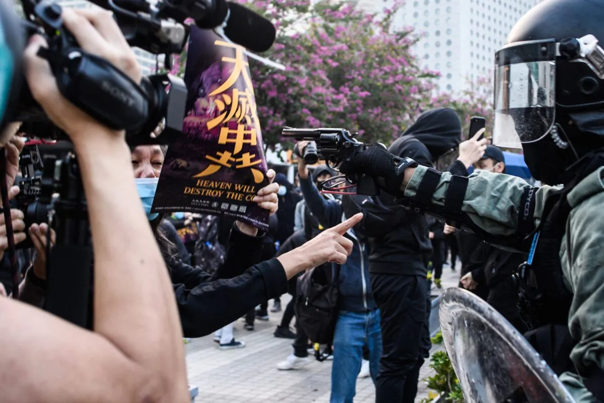 A police officer points a pistol during a rally in Hong Kong on Dec. 22, 2019. (Anthony Wallace/AFP/Getty Images)